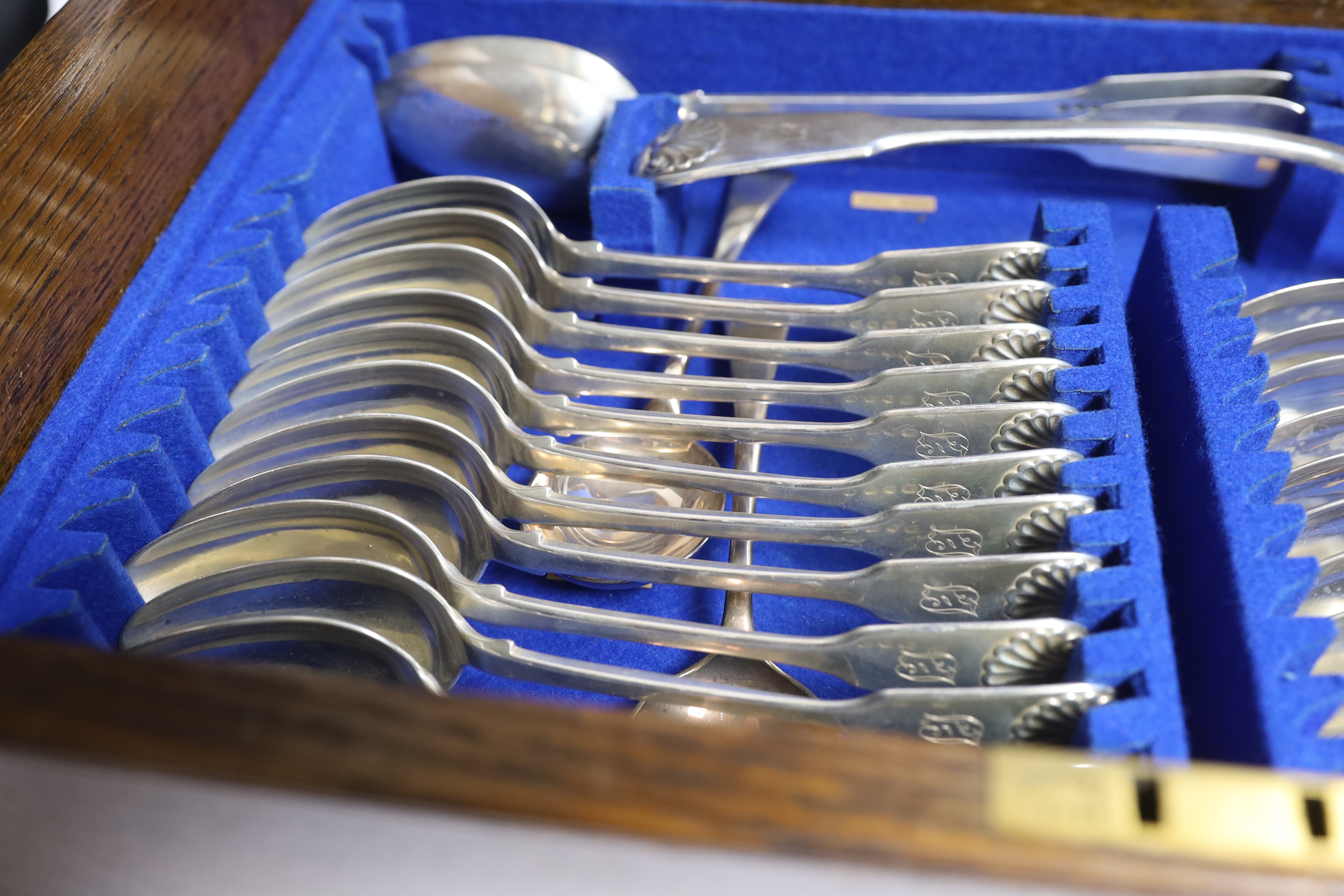 A Victorian oak cased matched canteen of silver fiddle and shell pattern flatware, by John & Henry Lias & H.J. Lias & Son